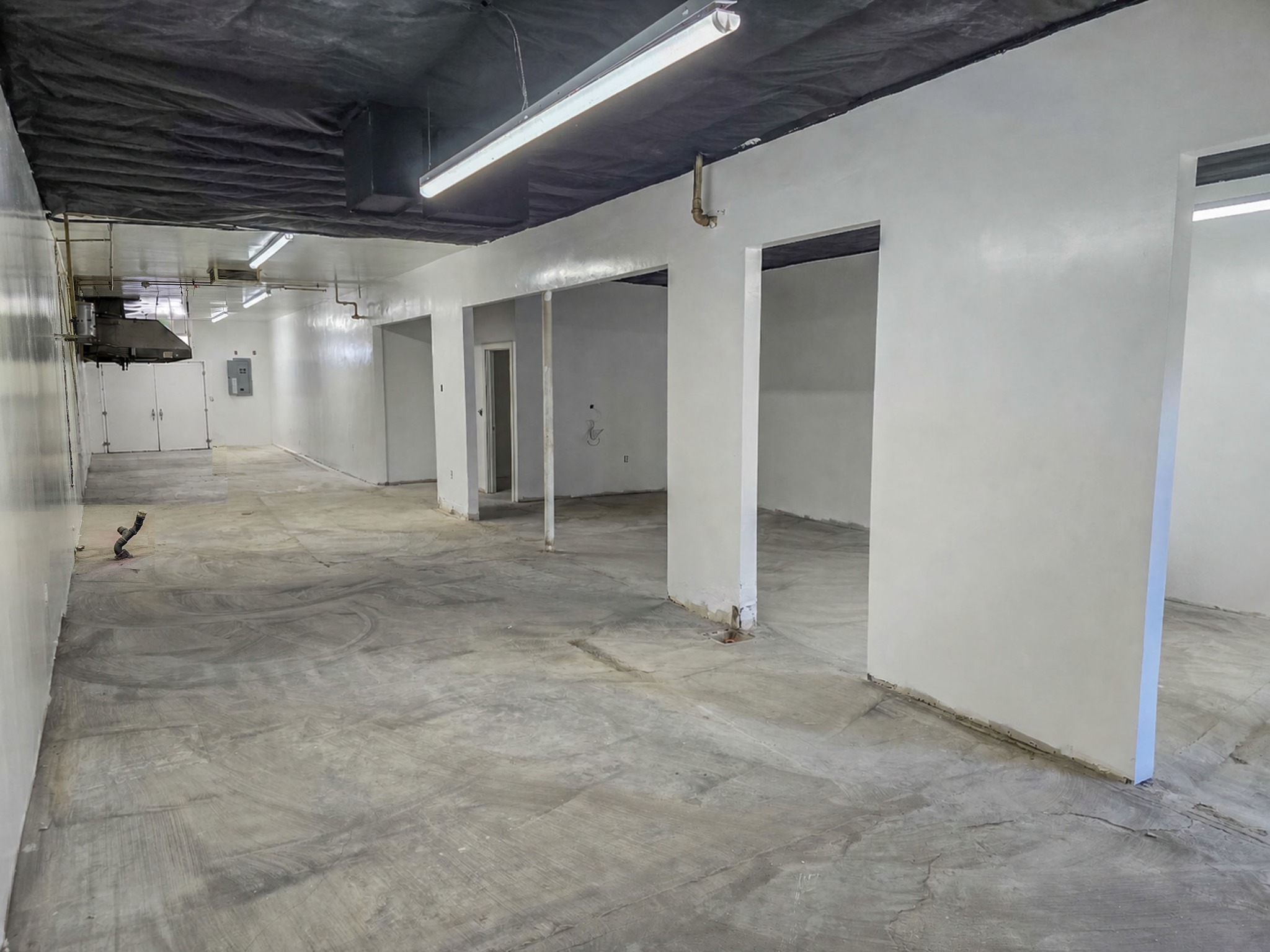 Interior of 668 Lancaster Blvd showing the long floor plan and side rooms